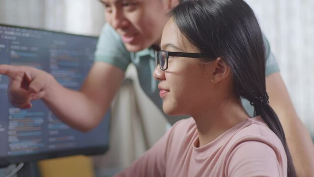 Close Up Of Asian Teen Girl Students Studying Software Code From Male Teacher Or Father
