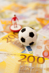 miniature soccer player and euro banknotes, sport as  business concept