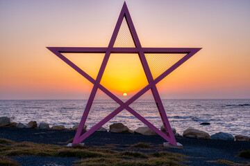 sunrise on the sea, looking through a pentagram sculpt