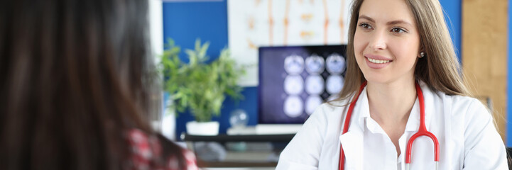 Beautiful female doctor working with patient measures blood pressure