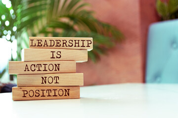 Wooden blocks with words 'Leadership is action not position'.