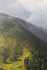 clouds over green hills on the top of the mountains