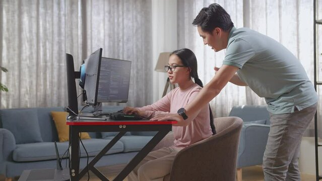Asian Father Teaching His Daughter Creating Software Engineer Developing App, Program, Video Game On Desktop Computer At Home. Terminal With Coding Language
