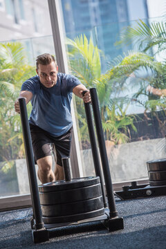 Man pushing weight sled in gym