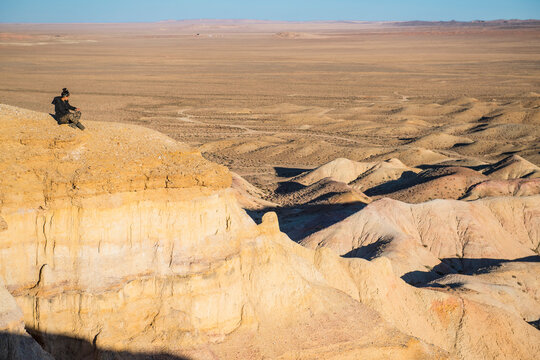 Woman sitting at edge of Flaming Cliffs, Mongolia