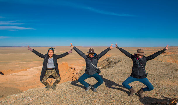 Hikers posing on top of Flaming Cliffs, Mongolia