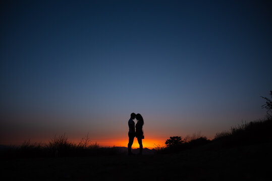 Young couple enjoying sunset in the mountains