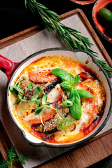 Baked eggplant with tomatoes, mozzarella cheese, basil and parmesan. Italian Sicilian cuisine - Parmigiana di melanzane