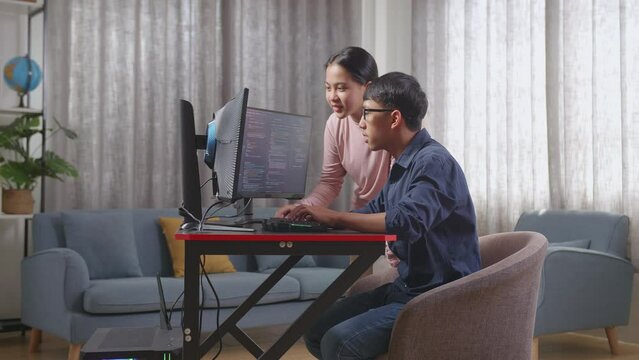 Asian Teen Boy Students Studying Software Code From His Sister
