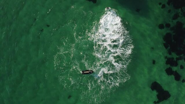A man flies on a FlyBoard. Aerial top down view. Water extreme sport, azure summer sea with outdoors active people enjoying water sports. Flyboarding and seariding, Recreation and sports concepts.