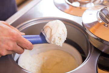 Ball of vanilla ice cream in ice cream razor in cafe