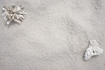 Table top motif of a beach with a coral in the upper left corner as a decorative element. Fine sand texture.