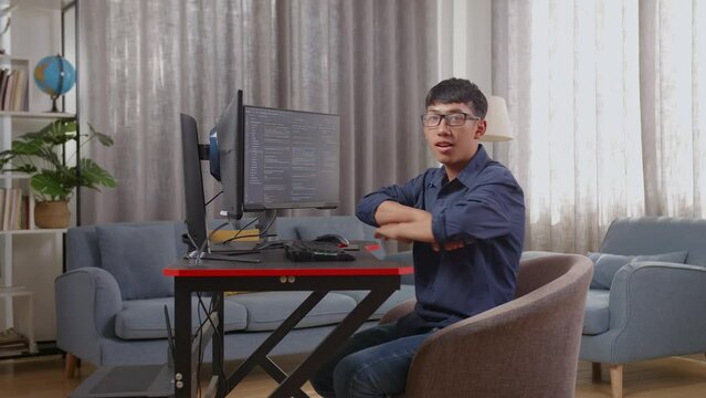 Asian Boy Programmer Smiling And Crossing Her Arms While Creating Software Engineer Developing App, Program, Video Game On Desktop Computer At Home
