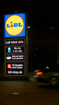 Lidl logo on parking lot at night. Car in motion. Altbach, Germany.