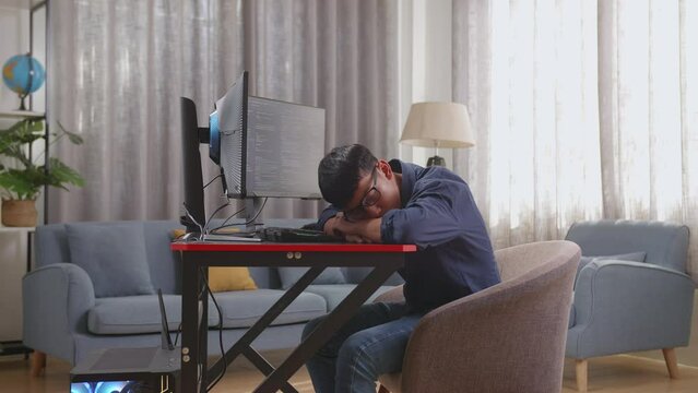 Asian Boy Programmer Sleeping While Creating Innovative Software Engineer Developing App, Program, Video Game On Desktop Computer At Home. Terminal With Coding Language 

