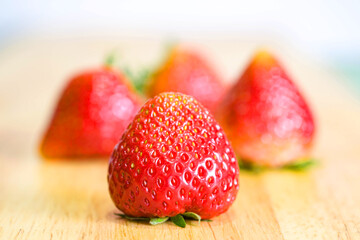 Strawberries placed on a wooden tray with soft background , selective focus