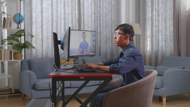 Asian Boy Programmer Learning Online From Teacher On Desktop Computer While Creating Software Engineer Developing App, Program, Video Game At Home. Terminal With Coding Language 
