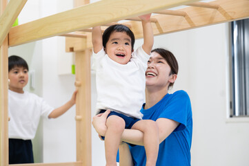 スポーツクラブや保育園でうんていをする子供