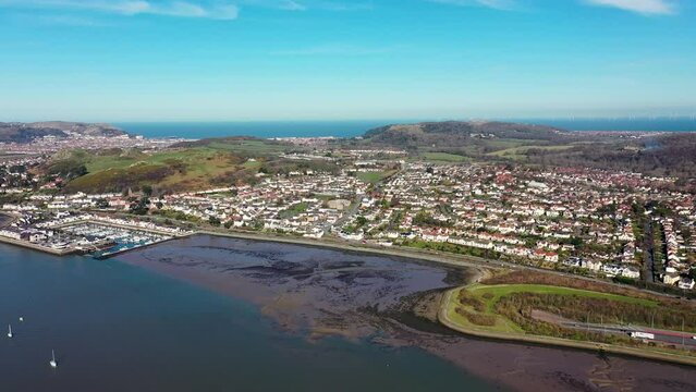 Aerial footage of the town of Deganwy in Conwy County Borough in Wales It lies in the Creuddyn Peninsula alongside Llandudno Rhos-on-Sea showing the A55 North Wales Expressway along the Conwy river