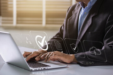 Businessman working on labtop with check mark, document symbol, and standard quality control. The concept of ISO service, international standards and quality assurance is certified.
