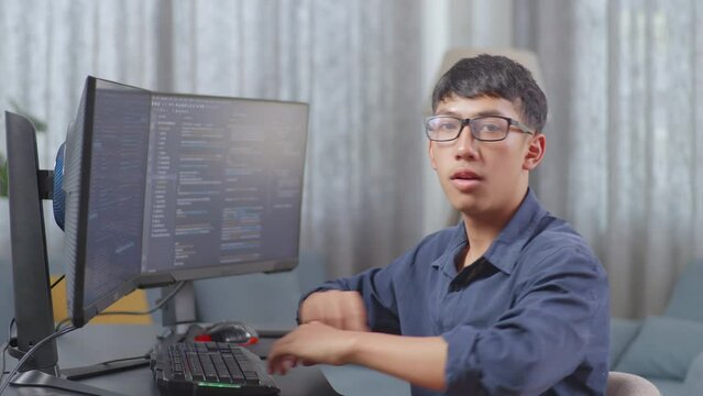 Asian Boy Programmer Smiling And Crossing Her Arms While Creating Software Engineer Developing App, Program, Video Game On Desktop Computer At Home
