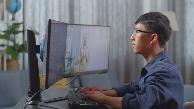 Asian Boy Programmer Learning Online From Teacher On Desktop Computer While Creating Software Engineer Developing App, Program, Video Game At Home. Terminal With Coding Language 
