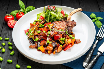 grilled pork steak with a bone in a sweet honey glaze and vegetable stew with green beans