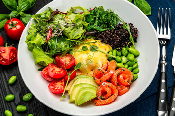 Healthy light breakfast with poached egg, salmon, avocado, tomato, lettuce and chia seeds