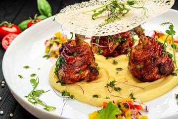 Chicken legs wrapped in bacon with barbecue sauce on mashed potatoes