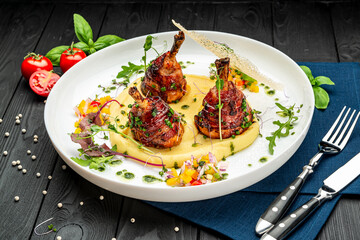 Chicken legs wrapped in bacon with barbecue sauce on mashed potatoes