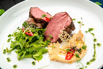 Veal medallion with salad and hummus hummus