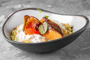 grilled salmon fish fillet with creamy ptitim, cheese and caviar