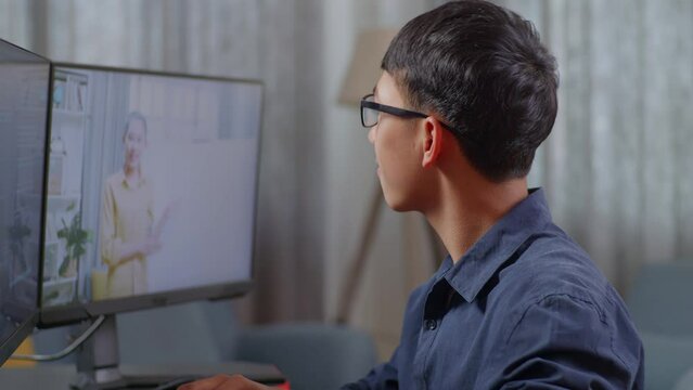 Close Up Of Asian Boy Programmer Learning Online From Teacher On Desktop Computer While Creating Software Engineer Developing App, Program, Video Game At Home. Terminal With Coding Language 
