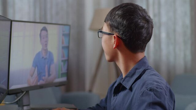 Close Up Of Asian Boy Programmer Learning Online From Teacher On Desktop Computer While Creating Software Engineer Developing App, Program, Video Game At Home. Terminal With Coding Language 
