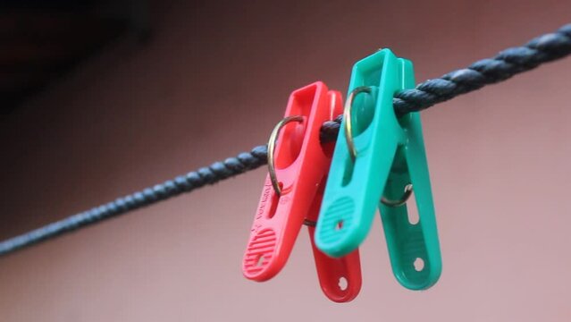 Selective focus, green and red clothespins on a fast moving clothesline with background blur. suitable for laundry