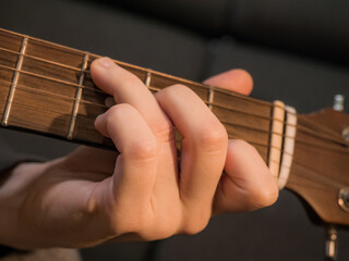 Practice playing the acoustic guitar. Hands playing guitar and picking chords