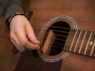 Obraz premium Practice playing the acoustic guitar. Hands playing guitar and picking chords