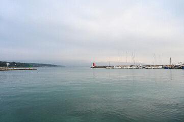 Cloudy day at sea. A lighthouse in the distance.