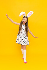 Holidays, the concept of the Easter holiday. Portrait of a beautiful girl, a romantic little girl in a beautiful polka dot dress with bunny ears, happily smiling, celebrating Easter,