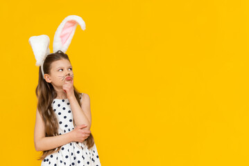 Cute attractive girl with Easter bunny ears gave a thumbs up, Easter day and egg coloring.