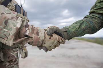 Handshake of two military soldiers in gloves