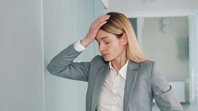 Sad Young Disappointed Business Woman Holds Hand to Head, Depressed by Financial Results, Problems at Work, Covering Face with Hands. Atmosphere of Depression, Trouble in Relationship, Bad News.