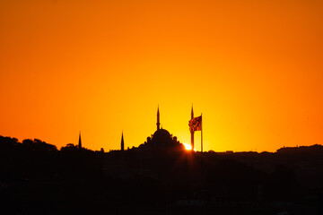Naklejka premium Fatih Mosque silhouette at sunset with Flag of Turkiye