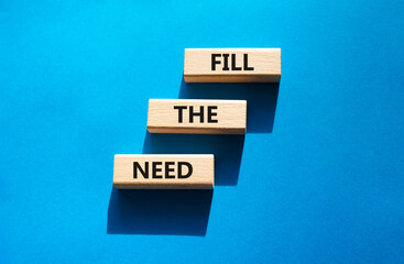Fill the need symbol. Concept word Fill the need on wooden blocks. Beautiful blue background. Business and Fill the need concept. Copy space