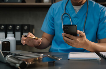 Medical technology concept. Doctor working with mobile phone and stethoscope and digital tablet laptop in modern office.