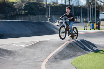 a happy boy sets up a racetrack in Park in summer