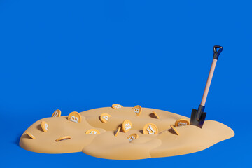 Shovel in sand with golden bitcoins, copy space
