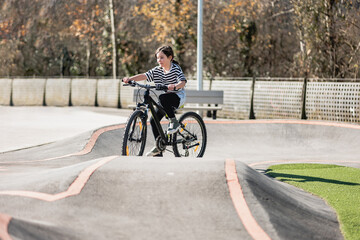 Obraz premium Smiling child riding bike. Learning to ride on run bicycle at skate park.