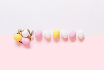 Willow branches and candy Easter eggs on a light white pink background. Happy easter flat lay. copy space