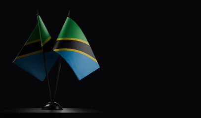 Small national flags of the Tanzania on a black background